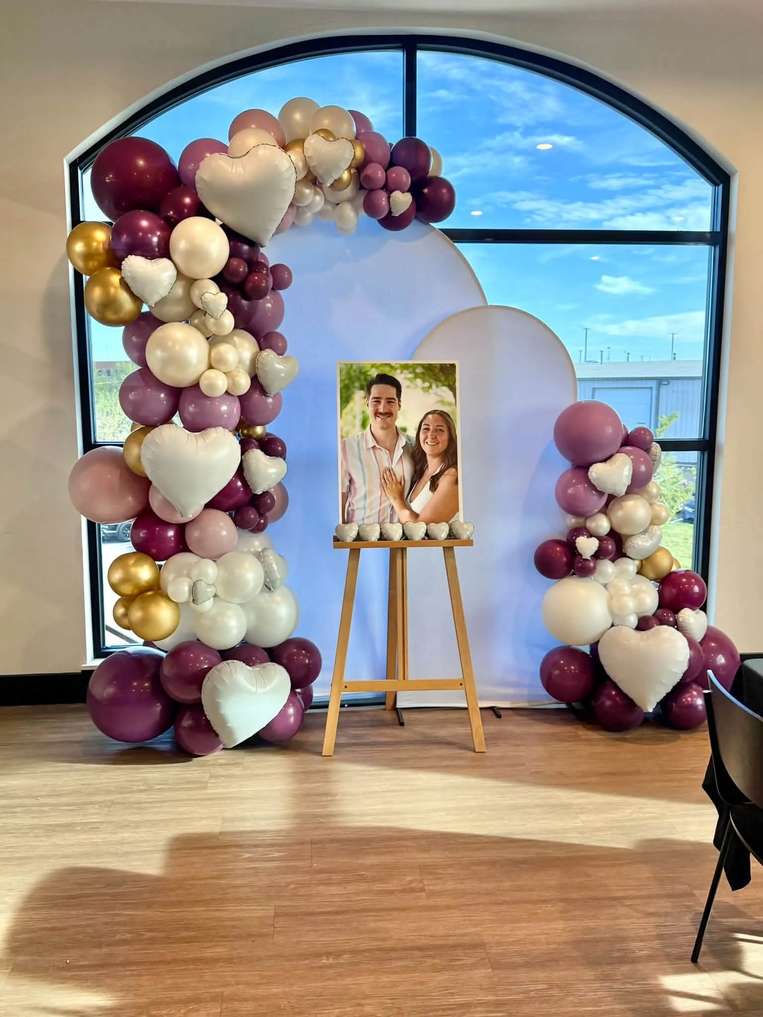 Burgundy, mauve, pearl and gold engagement arch with heart balloons