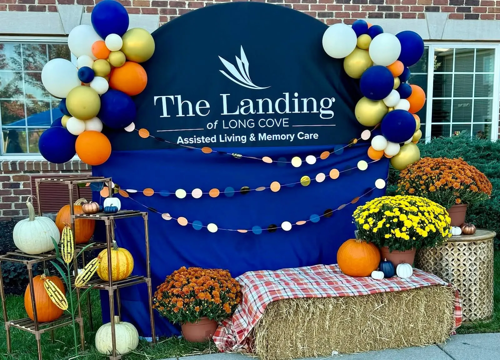 Navy, gold, orange and cream balloon clusters on a fall festival sign backdrop